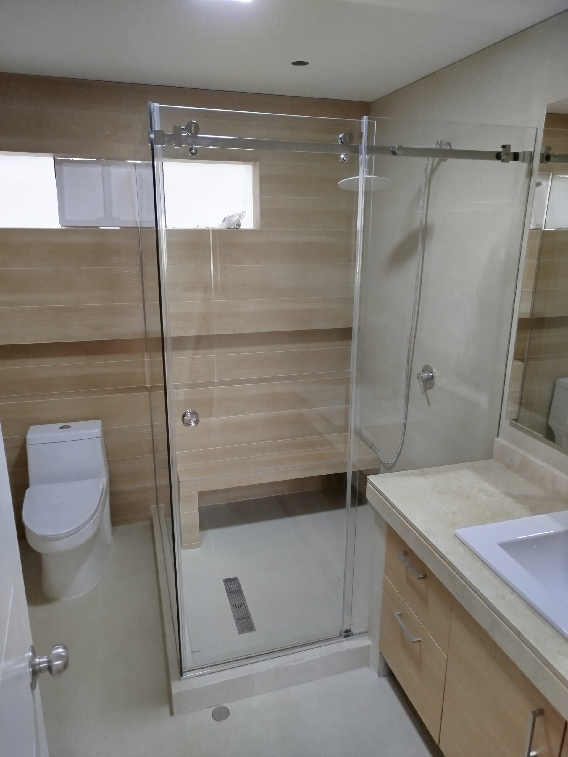 Mampara de ducha de cristal templado transparente con sistema corredizo de acero inoxidable en Lima.